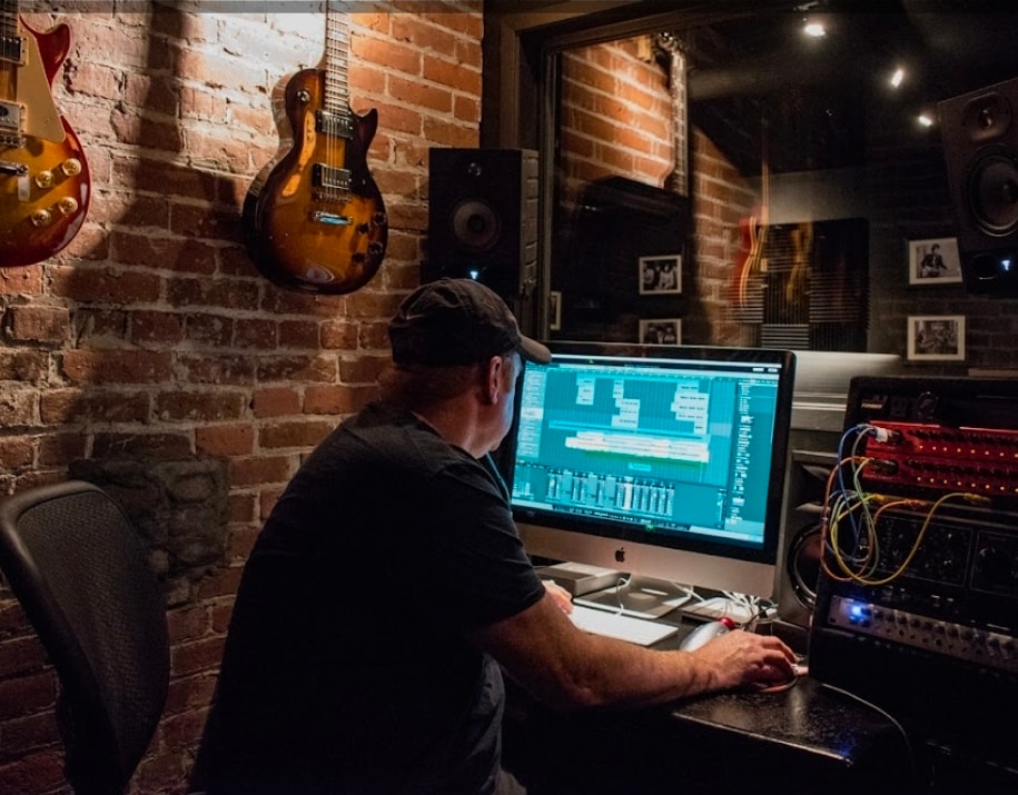 Vocalist recording in studio booth